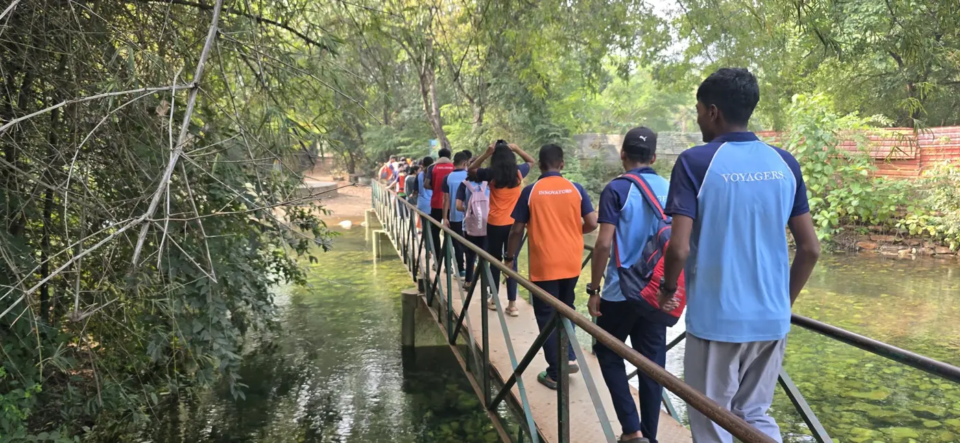 Students crossing a footbridge on a forest trail