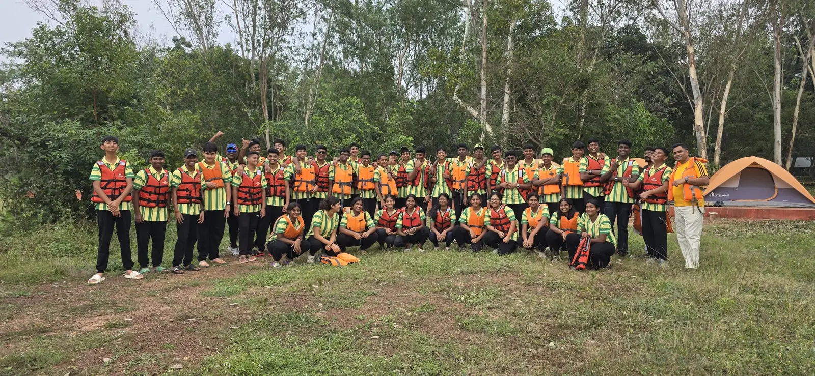 A large school group wearing life jackets before a water activity