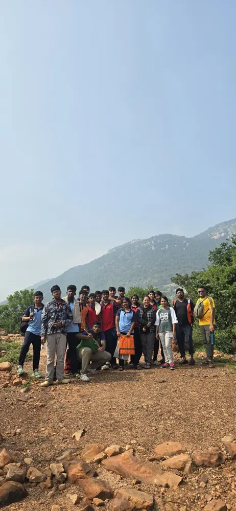 A school group on a hill trail with mountains behind