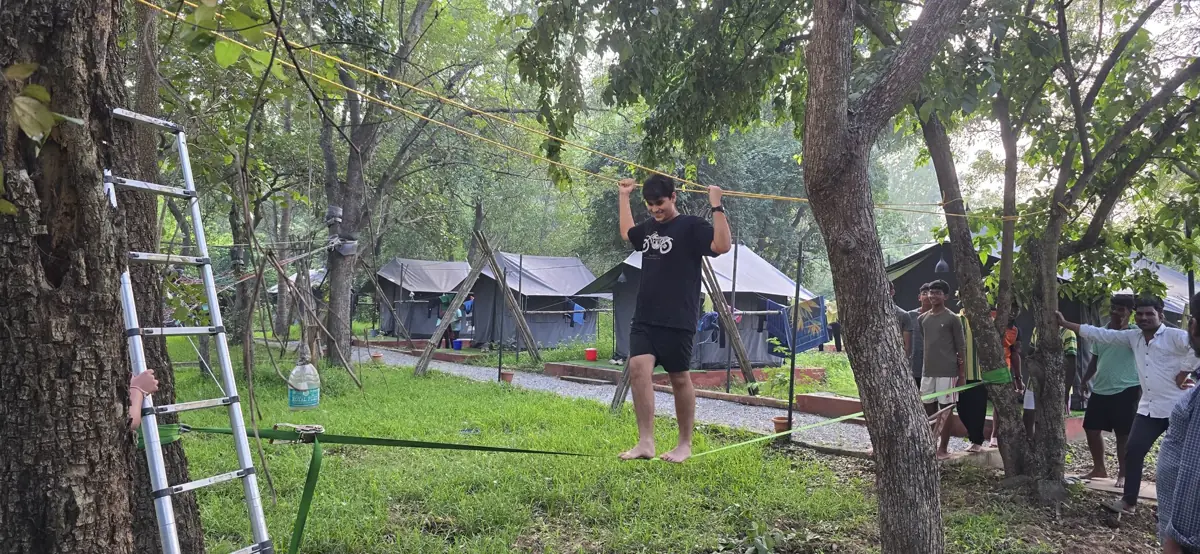 A student on a rope course between trees